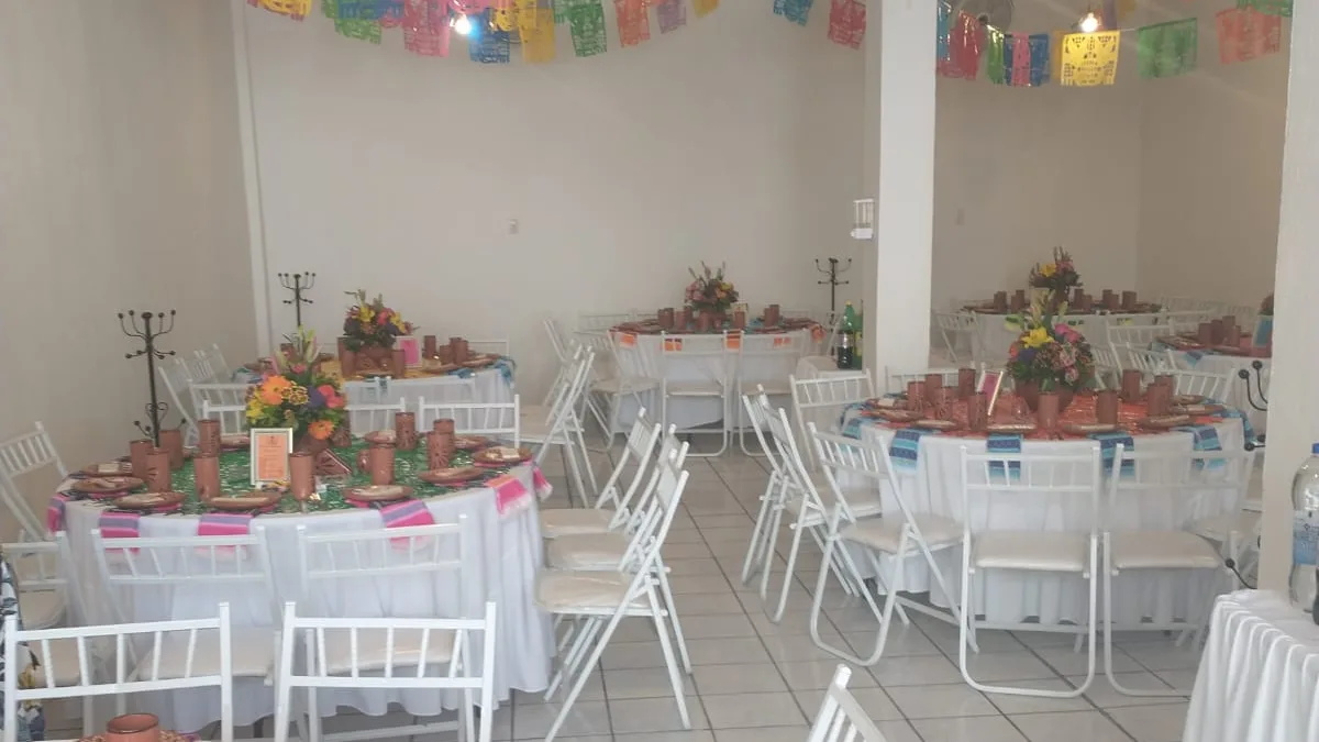 Mesas montadas con decoración de papel picado