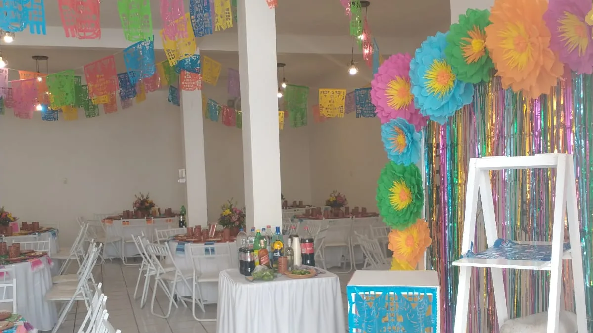 Salón con papel picado y fondo de flores